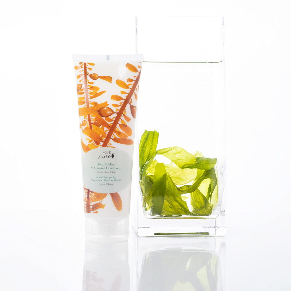100% PURE bottle held in hand to show real size and portability