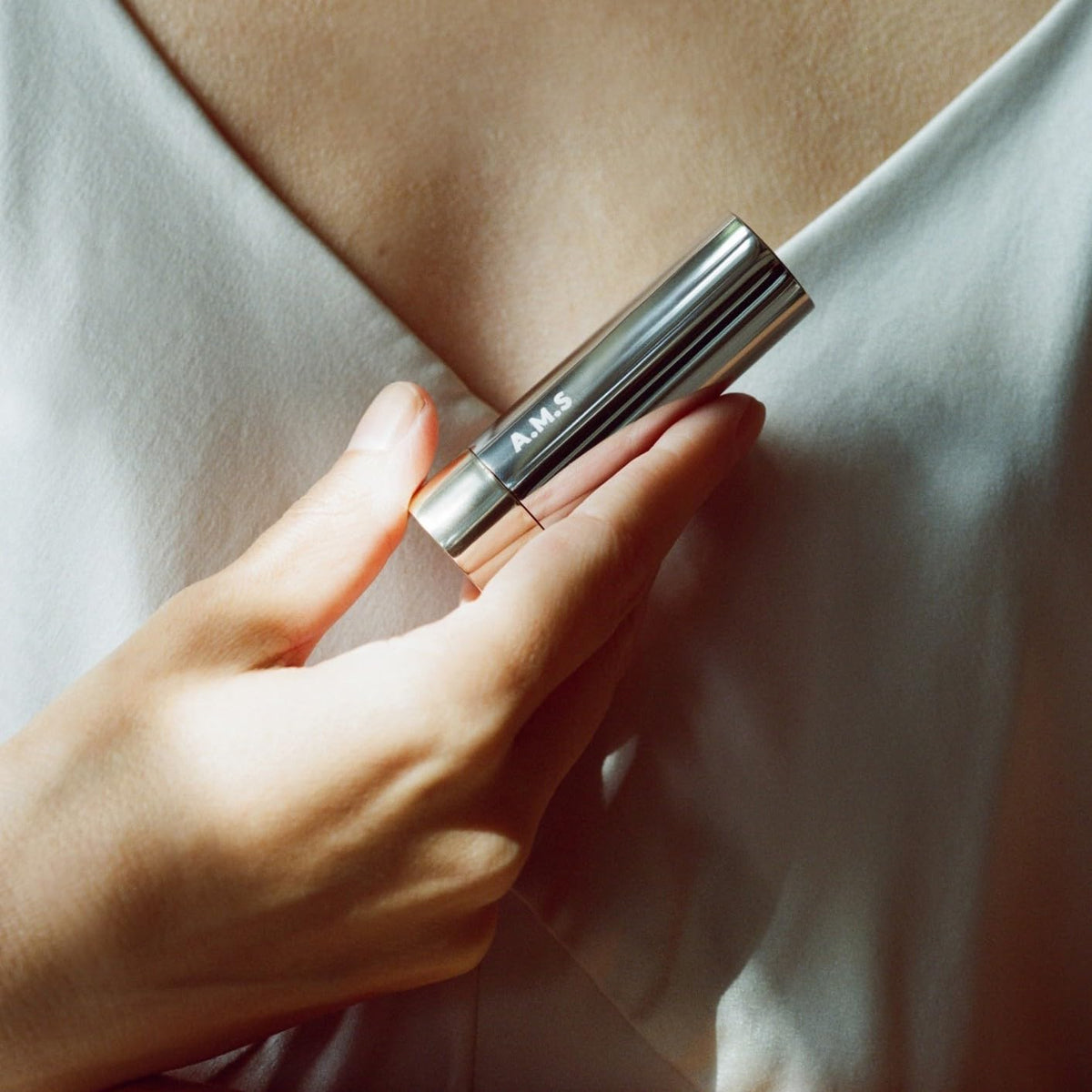 ACTIVIST lip balm held in hand illustrating compact travel-friendly size