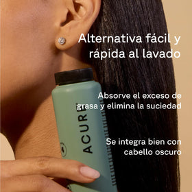 Acure dry shampoo held in hand to show compact size and travel benefit