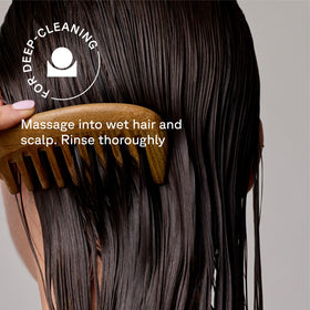 Acure conditioner being applied to mid-lengths demonstrating targeted moisture benefit