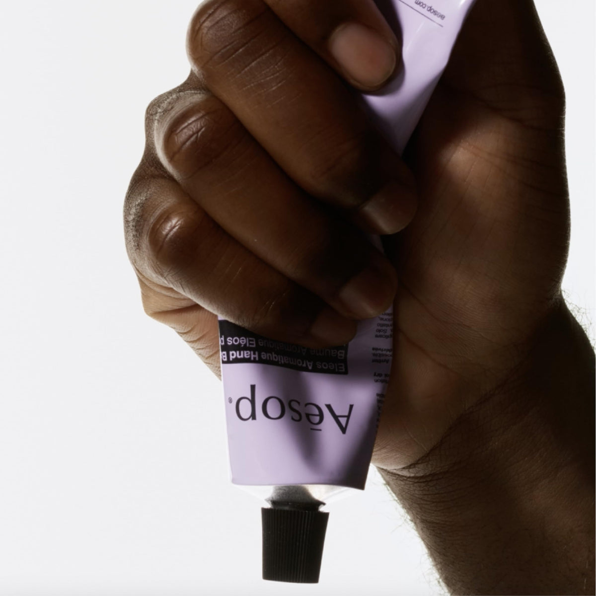 Aesop Eleos beside passport and key, travel-size convenience highlighted
