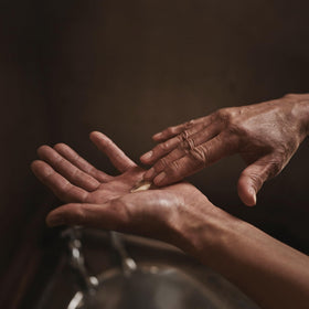 Hand applying Aesop balm to forearm showing quick absorption and visible smoothing benefit