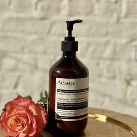 Macadamia nuts and oil beside product, highlights Aesop nourishing ingredient benefit
