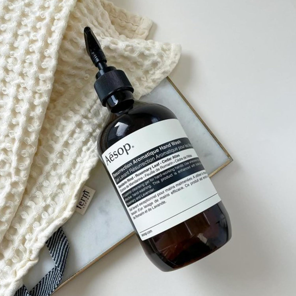 Aesop refill next to a common soap bottle for scale, clarifying 16.9 oz size and refill convenience