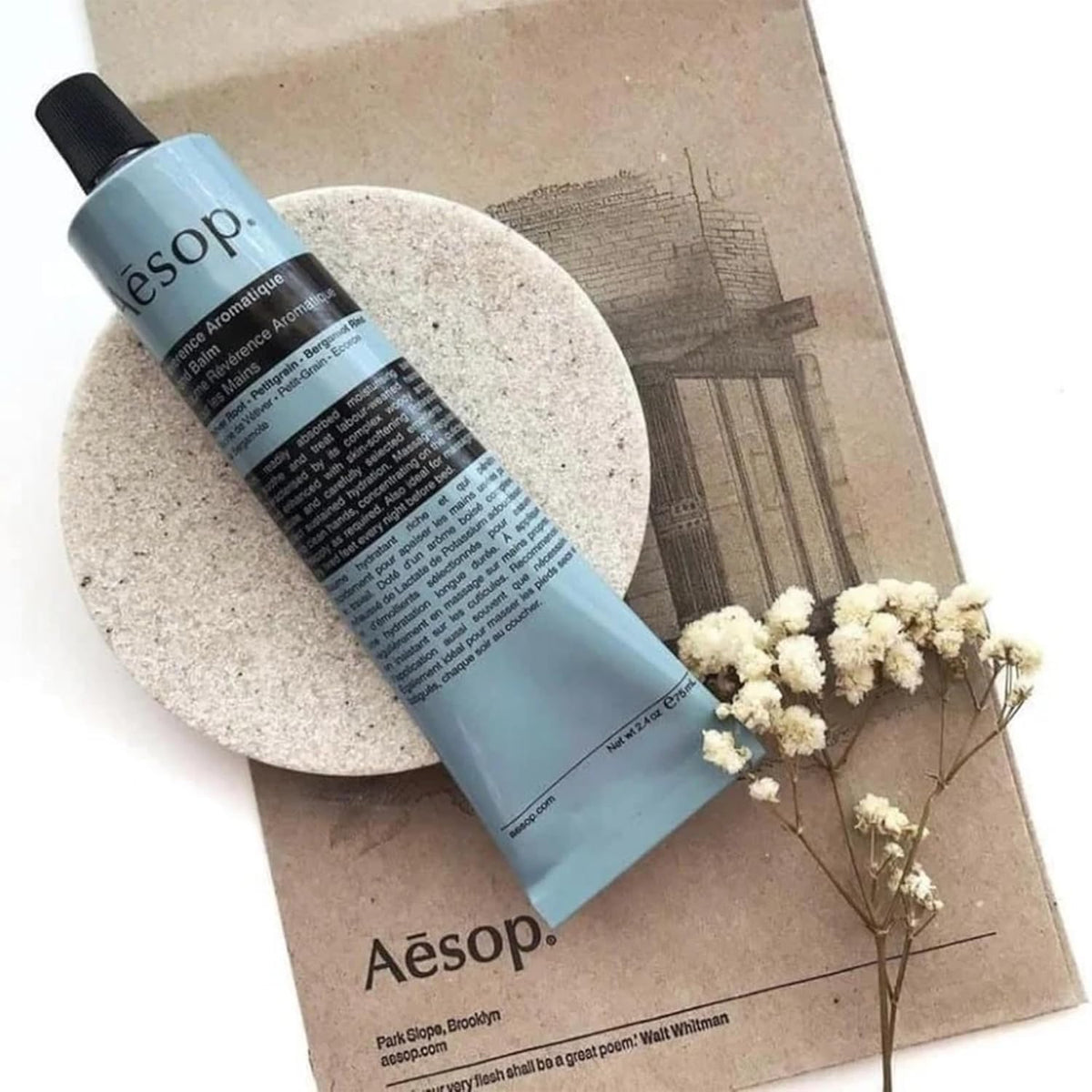 Aesop tube next to travel pouch showing compact size and portability benefit