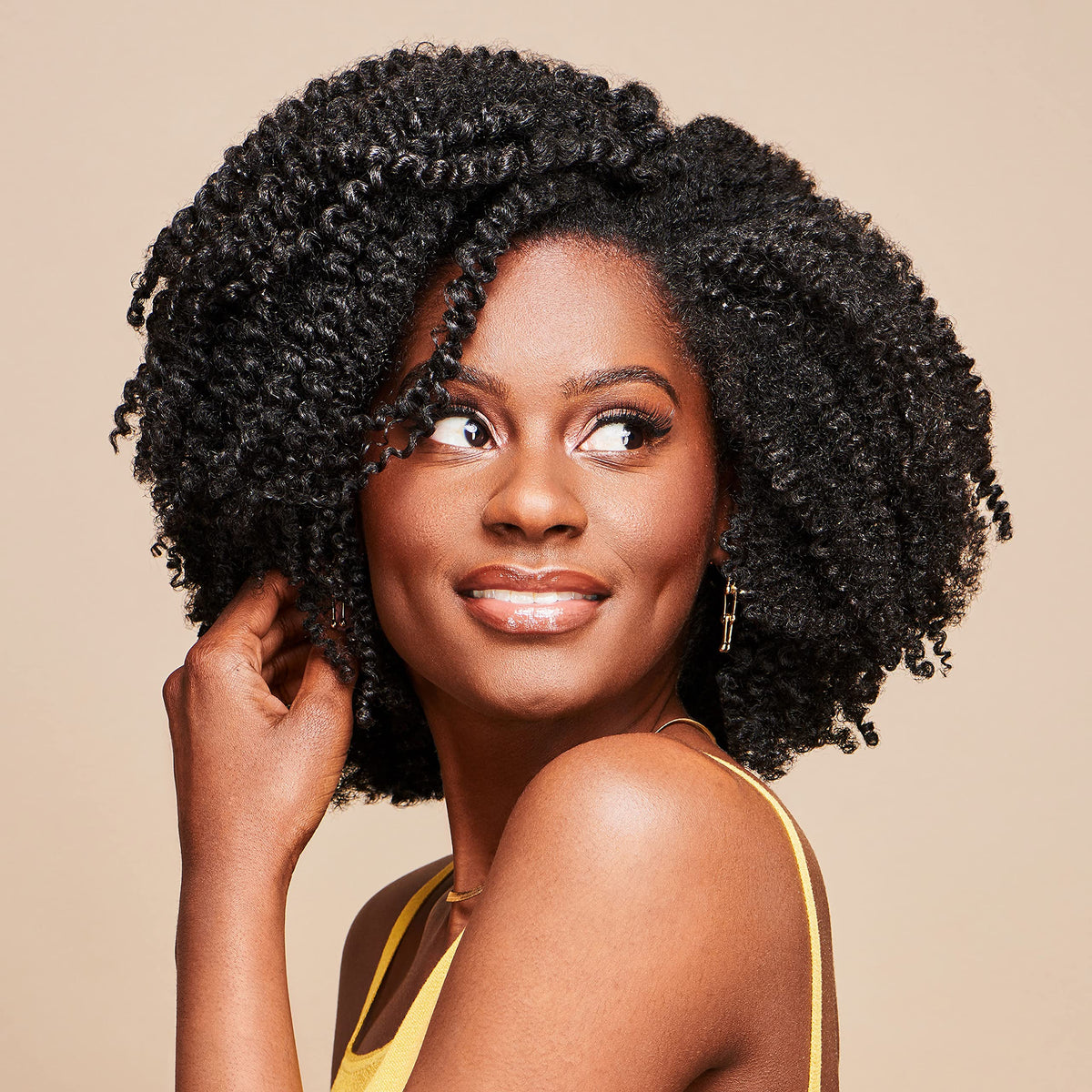 African Pride cream being smoothed into curls for improved manageability