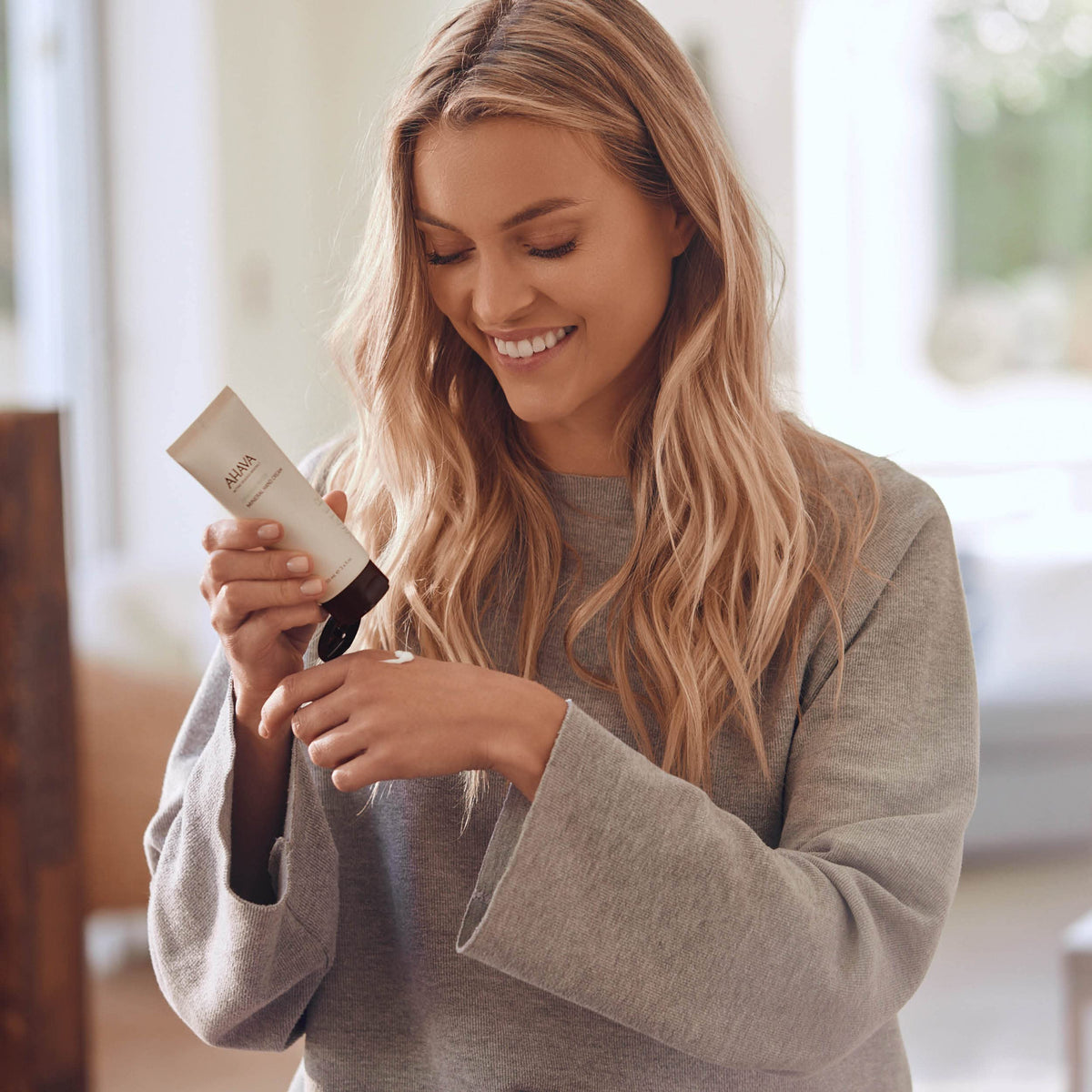 AHAVA hand cream on bathroom counter illustrating daily skincare routine