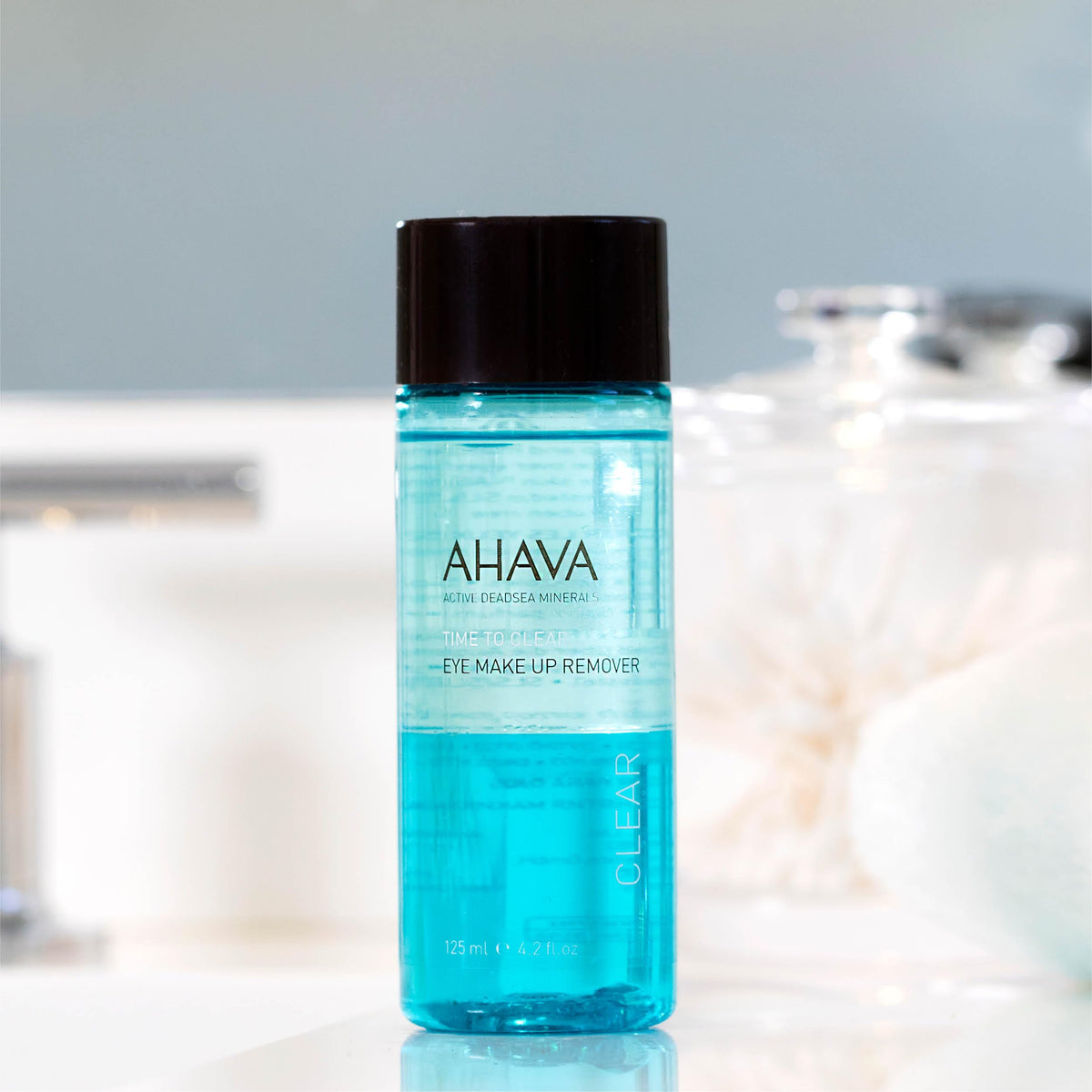 AHAVA next to travel items for size comparison, showing portable 4.2 fl oz bottle convenience benefit