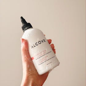 Alcôve bottles in hand size scale demonstrates portable 10 ounce usability