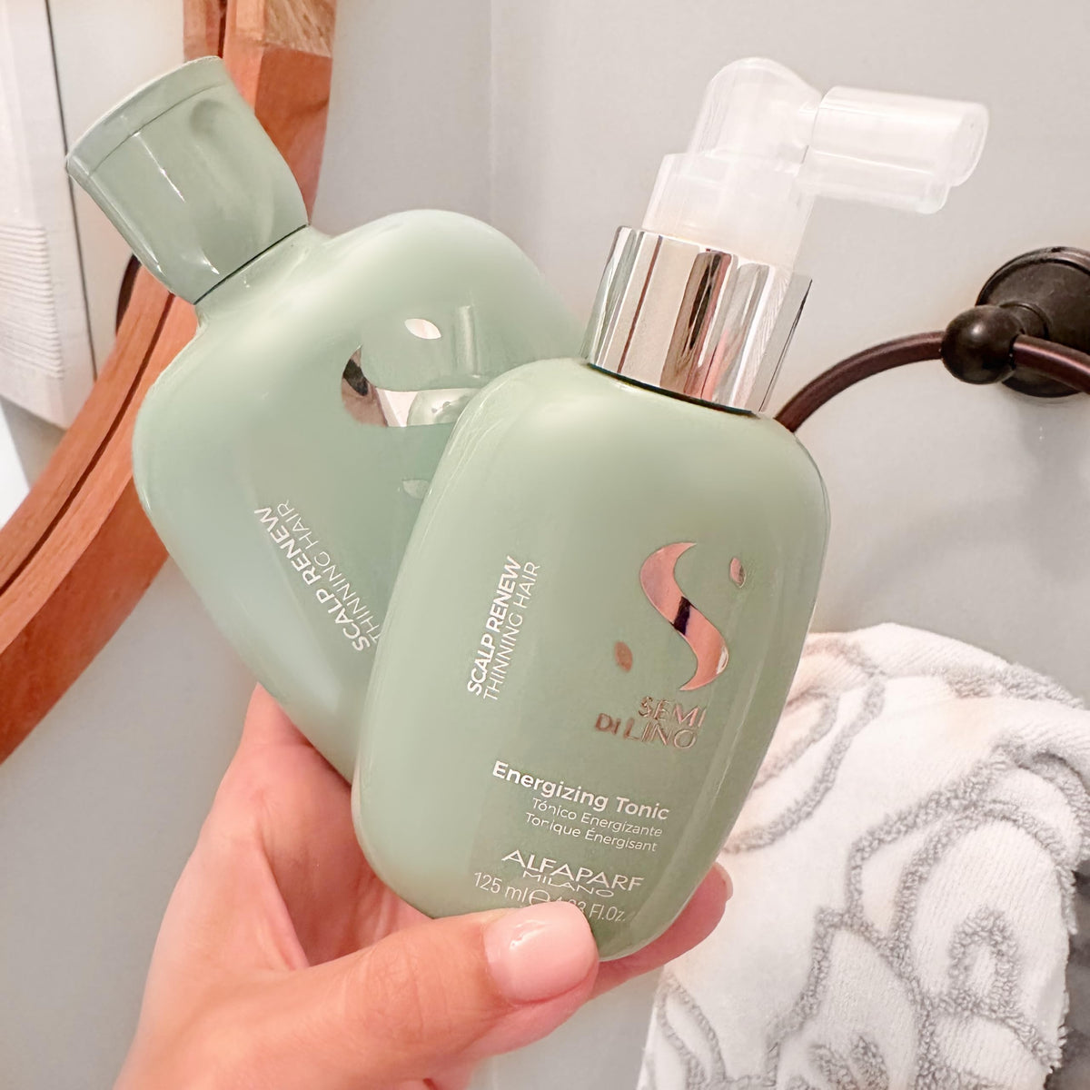 Alfaparf Milano bottle size comparison next to hands showing travel-friendly 4.23 fl oz