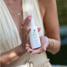 ALOE UP tube next to hand showing compact travel-friendly size