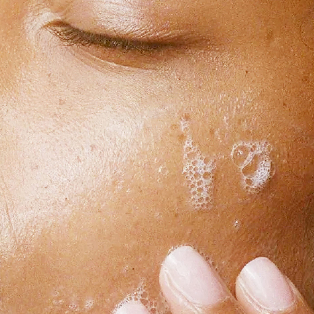 Alpha face wash in hand while rinsing to show easy daily use