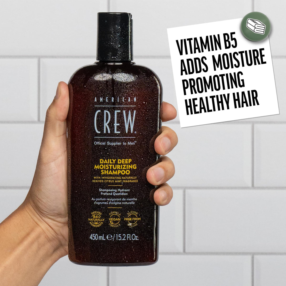 American Crew bottle in shower being applied to wet hair for daily cleansing and hydration