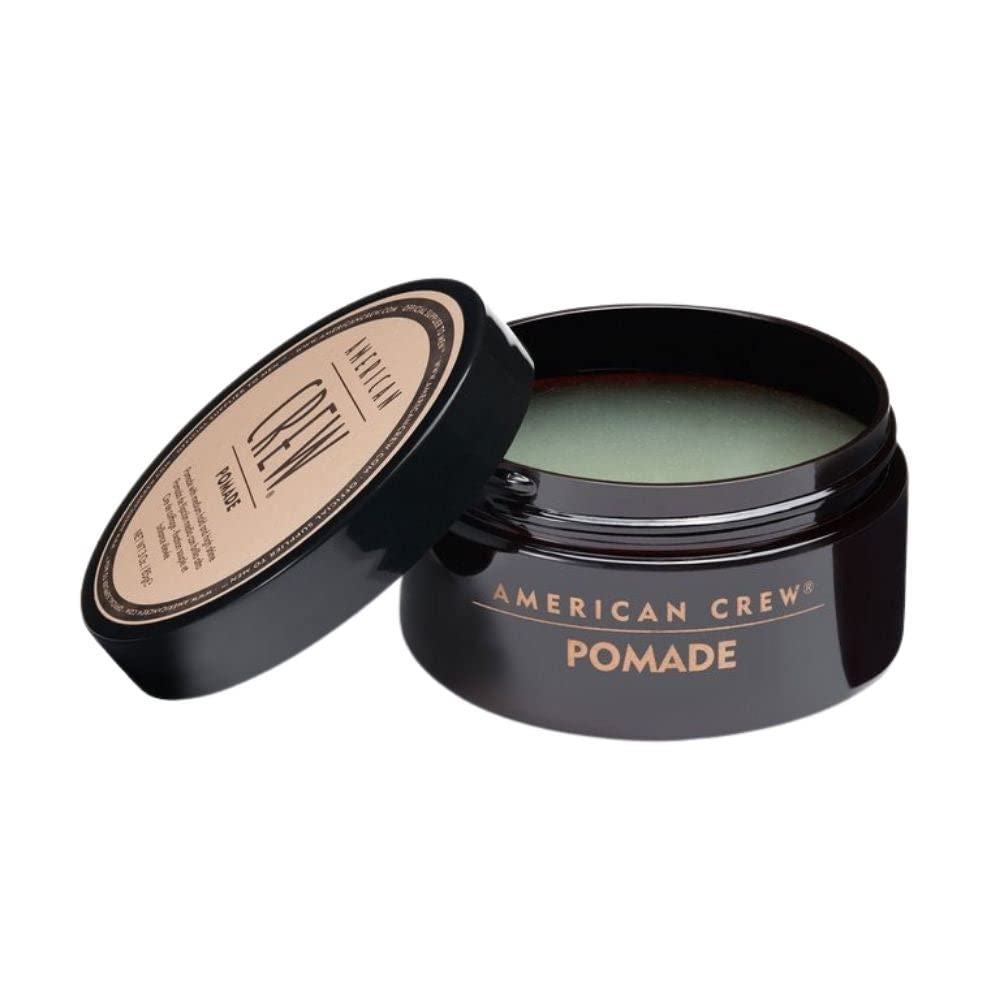 American Crew pomade texture close-up on fingertips, demonstrating smooth, spreadable consistency
