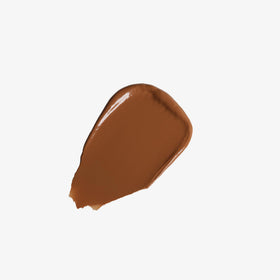 Hand holding Anastasia Beverly Hills balm to show size and portability, travel-friendly benefit