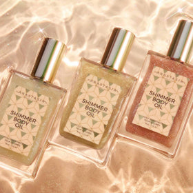 Anastasia Beverly Hills bottle in beach lifestyle scene evoking tropical coconut-vanilla scent
