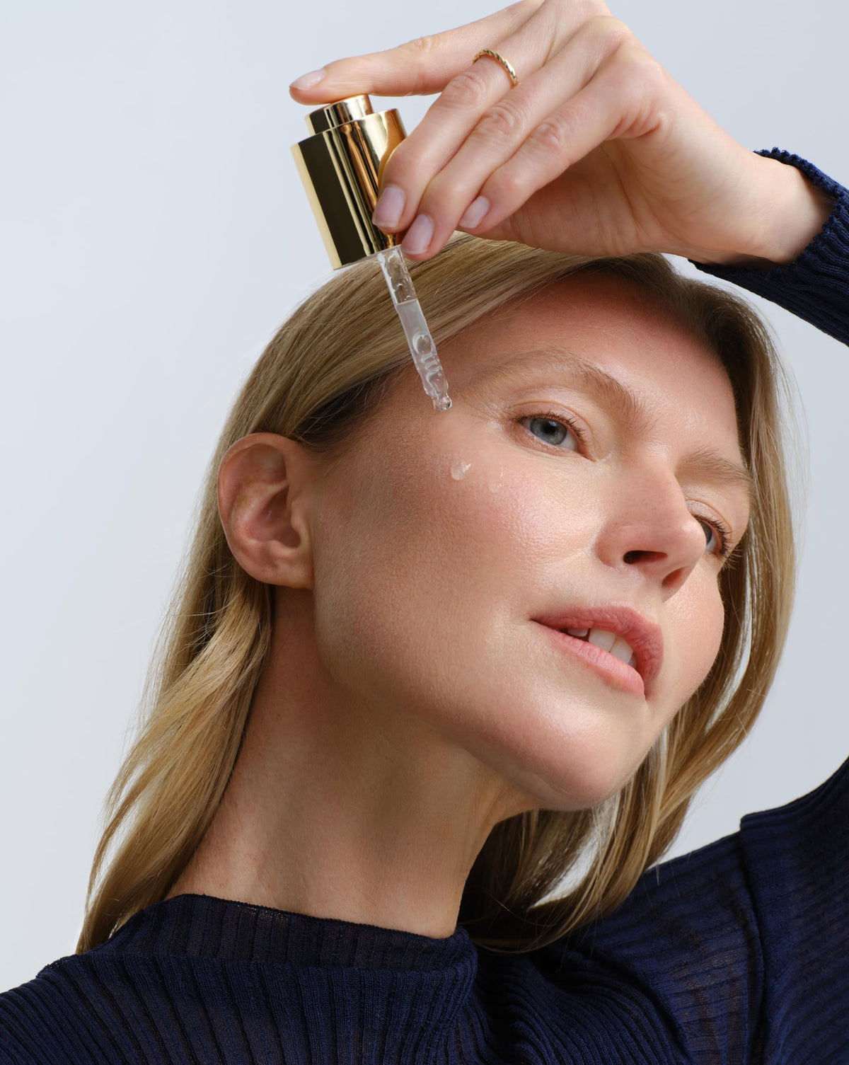Angela Caglia serum beside sunscreen representing daytime routine skin protection benefit
