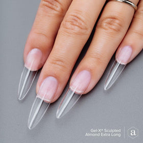 APRÉS tips worn on model hand for scale, shows extra-long almond length