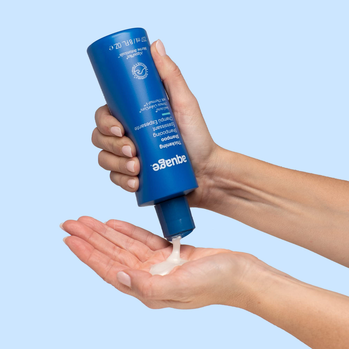 Model applying Aquage thickening shampoo, showing improved body and root lift benefit