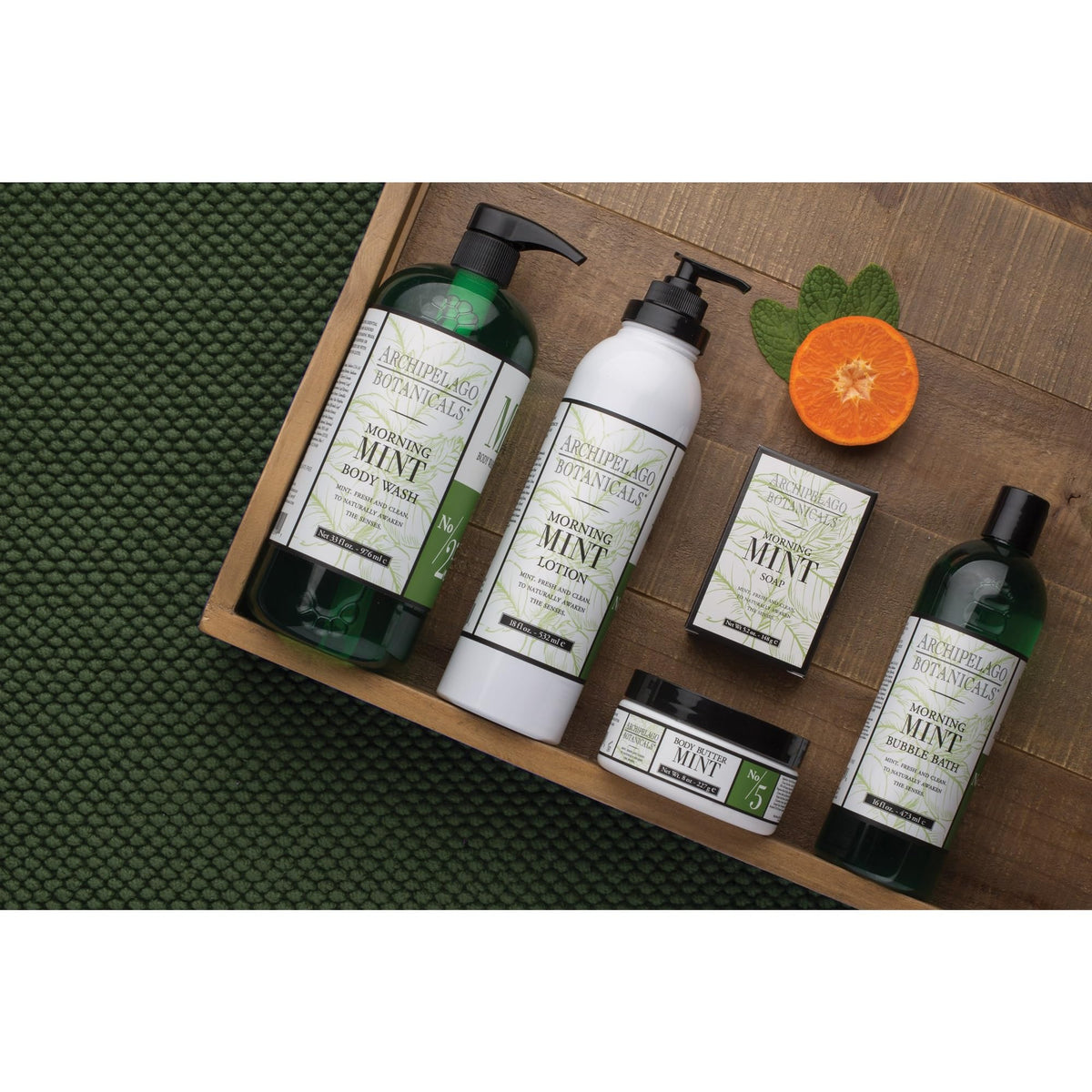 Archipelago Botanicals bottle next to a water glass showing 33 oz size and value benefit
