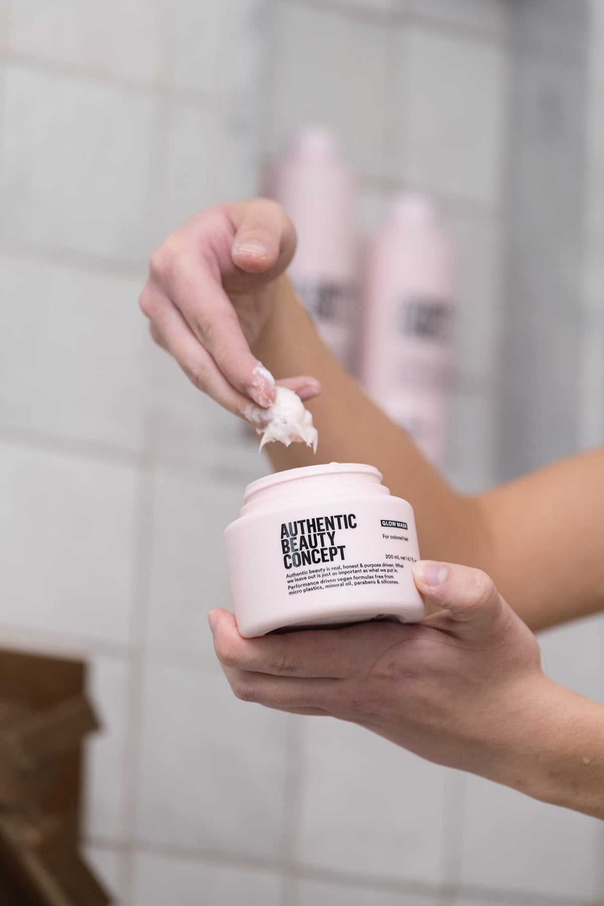Authentic Beauty Concept applying mask to hair strands for deep conditioning benefit