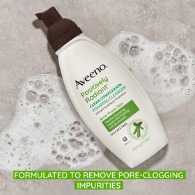 Aveeno bottle in hand for scale and one-handed everyday use