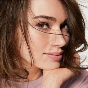 AVON applying cream to cheek demonstrating easy absorption benefit overnight