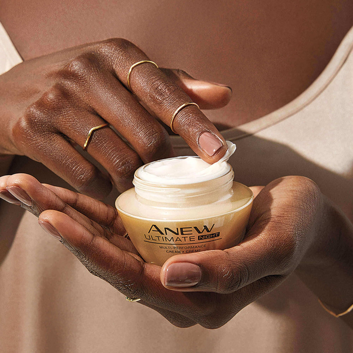AVON cream on fingertip demonstrating silky texture for easy application
