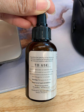 Bask & Lather bottle held next to a hand for size and portion clarity