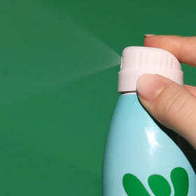 Bask bottle in hand to show 5.5 ounce size for travel convenience