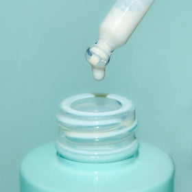 Bask 1 oz bottle next to sunglasses showing travel-sized convenience