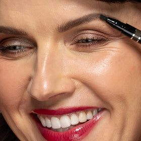 billion dollar brows pen held in hand demonstrating compact size and travel convenience