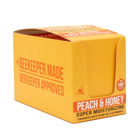 Beekeeper Made lip balm in hand, demonstrating peach balm application and portable benefit
