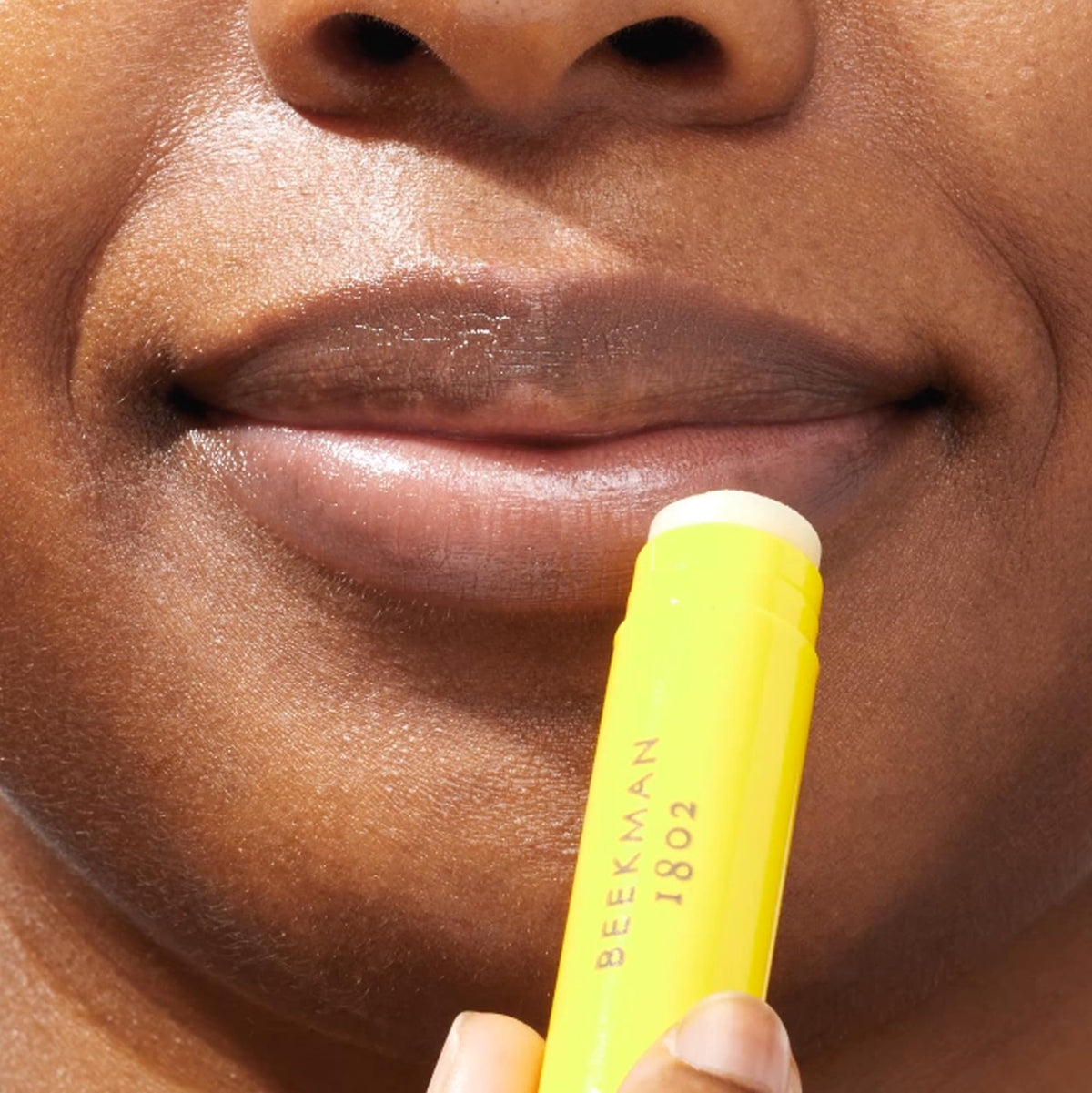 Beekman 1802 lips applying balm showing smoothing and soothing benefit