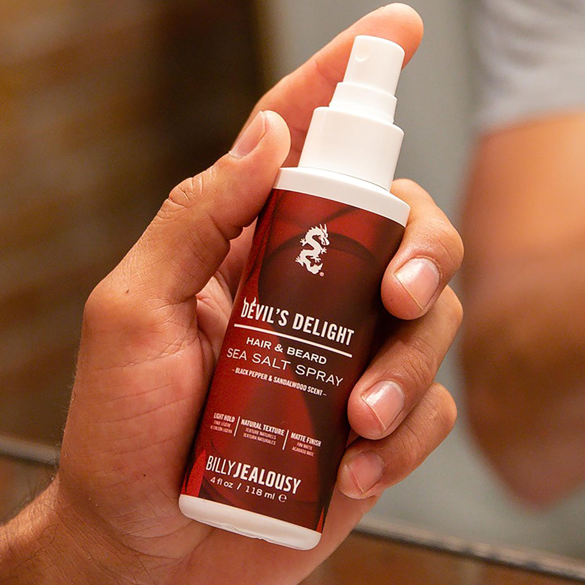 Billy Jealousy bottle held in hand to show the 4 fl oz portable size