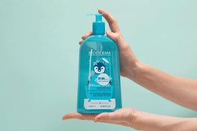 Bioderma ABCDerm bottle next to measuring cup showing 33.8 fl oz scale
