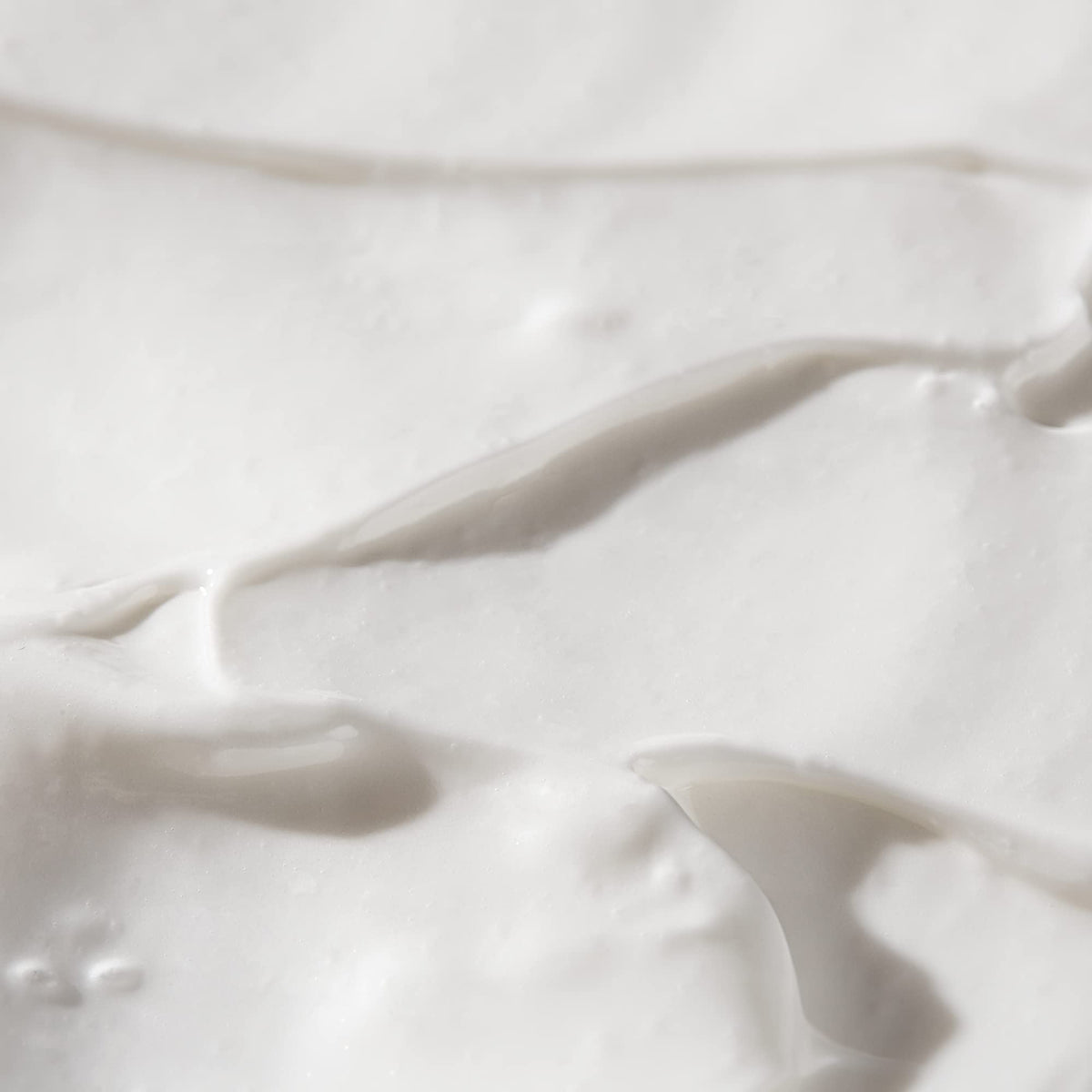 BIOSSANCE hand applying serum to cheek showing improved texture and glow