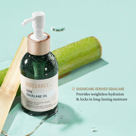 BIOSSANCE bottle next to common items showing scale of the 3.3 ounce size