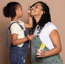 Black Girl Sunscreen application on child arm demonstrating easy, even coverage