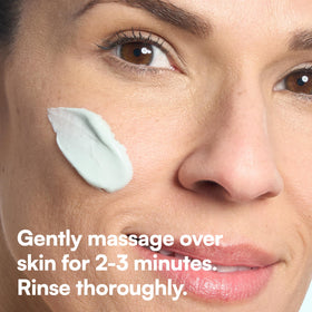 Bliss applying scrub to face in bathroom demonstrating gentle exfoliation
