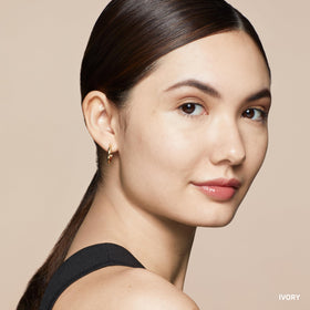 Bobbi Brown concealer stick next to foundation illustrating layering compatibility