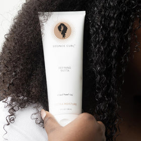 Bounce Curl scoop on hands demonstrating easy application and spreadability
