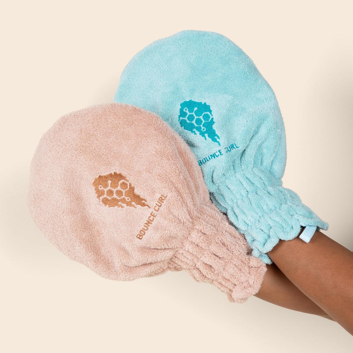 Bounce Curl mitten beside hand showing compact size and portability