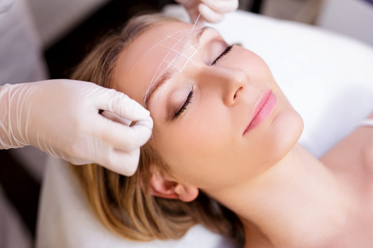 BRAWNA professional brow artist using thread to measure and create symmetrical brows