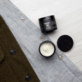 Brickell clay pomade texture closeup on fingers highlighting creamy matte grip benefit