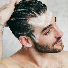 Brickell man in shower applying shampoo illustrating calming scalp care