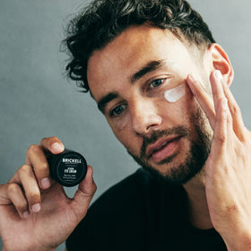Brickell Men's Products eye cream application on male skin reducing puffiness