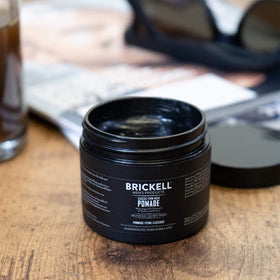 Brickell Men's Products styled slick-back in mirror illustrating strong hold and shine benefit