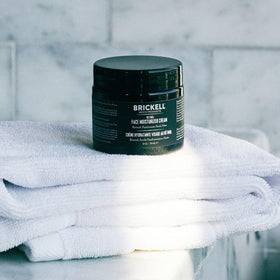 Brickell 2 oz jar in hand showing compact travel-friendly size
