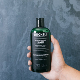 Brickell 8oz bottle held in hand showing compact travel-friendly size